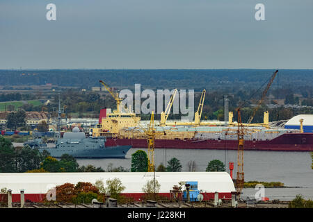 Militärisches Schiff Segeln vorbei an den Frachthafen in Riga, Lettland Stockfoto