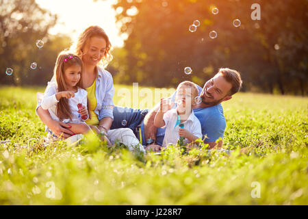 Kinder freuen sich bei der Herstellung von Seifenblasen außerhalb Stockfoto