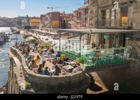 Porto Portugal Ribeira, Touristen entspannen sich auf einer Café-Terrasse auf einem Steinsteg der ursprünglichen Brücke entlang der Cais da Ribeira Waterfront in Porto gebaut. Stockfoto