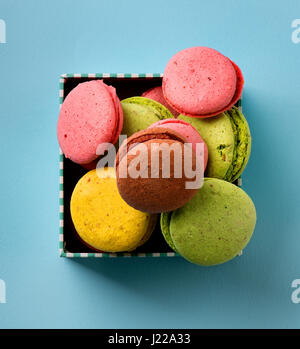 Bunte Macarons in einer Geschenkbox auf blauem Hintergrund Stockfoto