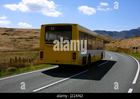 Bus auf ländlichen Mountain Road. Snowdonia National Park, North Wales, Vereinigtes Königreich. Bus auf britische Landschaft, malerischen Blick im Hintergrund. Reisen, Großbritannien. Stockfoto