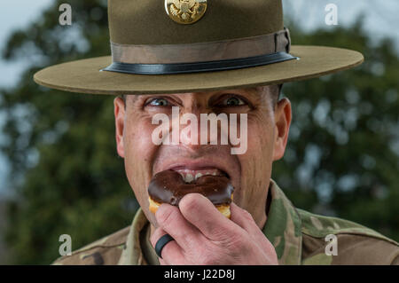 Sgt. 1. Klasse Joshua Moeller, US Army Reserve Drill Instructor und 2016 US Armee Unteroffizier des Jahres, Witze rund um durch einen Biss in einen Donut während einer Marketing-Foto-Shooting organisiert durch das Büro des Chief of Army Reserve in Fort Belvoir, Virginia, am 14. Februar, um der US Army Reserve zu fördern. (Foto: US Army Reserve Master Sgt. Michel Sauret) Stockfoto
