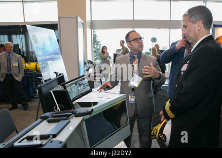 170404-N-RP435-023 NATIONAL HARBOR, MD., (4. April 2017) Herr Paul Baggerly, leitender Ingenieur und Trainer für die Marine der Intelligenz Handgepäck Programm (ICOP), bietet eine Demonstration des ICOP Systems für Programm Executive Officer Rear Admiral Carl Chebi, Programmbefehl Executive Office, Kontrolle, Kommunikation, Computer und Intelligenz (PEO C4I) und PEO Raumfahrtsysteme Navy League Sea-Air-Space Symposium. ICOP bietet einen konsolidierten Überblick über Intelligenz, Überwachung und Aufklärung Quellen Lageübersicht für Expeditionskorps zu verbessern. PEO C4I, PEO Raum und Partner progr Stockfoto