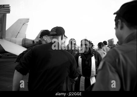 170416-N-AF077-159 BAHRAIN (16. April 2017) Commander John Logan, Marine Kaplan an Bord des Flugzeugträgers USS George H.W. Bush (CVN-77) (GHWB), wünscht Segler ein glückliches Ostern Folgendes Ostergottesdienst ein Sonnenaufgang auf dem Flugdeck statt. George h.w. Bush Carrier Strike Group in den USA bereitgestellt wird 5. Flotte Bereich der Maßnahmen zur Erhöhung der Sicherheit im Seeverkehr Operationen, Verbündete und Partner zu beruhigen, und bewahren die Freiheit der Schifffahrt eine den freien Fluss des Handels in der Region. (Foto: U.S. Navy Mass Communication Specialist 1. Klasse Sean Hurt/freigegeben) Stockfoto