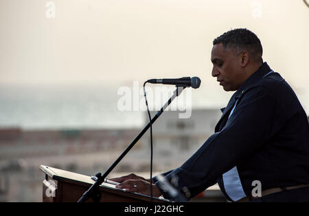 170416-N-OX430-086 BAHRAIN (16. April 2017) Commander John Logan, hielt Navy Kaplan an Bord des Flugzeugträgers USS George H.W. Bush (CVN-77) (GHWB), liest ein Gebet beim Sonnenaufgang Ostern Service auf dem Flugdeck. GHWB in den USA bereitgestellt wird 5. Flotte Bereich der Maßnahmen zur Erhöhung der Sicherheit im Seeverkehr Operationen, Verbündete und Partner zu beruhigen, und die Freiheit der Schifffahrt und den freien Fluss des Handels in der Region zu erhalten. (Foto: U.S. Navy Mass Communication Specialist 3. Klasse Daniel Gaither/freigegeben) Stockfoto