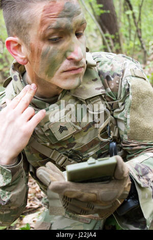 Sgt. Wilson Jackson, ein Bewohner von Houston, Texas und Mitglied der 45. Infantry Brigade Combat Team Teilnahme an der 7. Armee Traning Befehl Unteroffizier Academy Leader Grundkurs während in die Ukraine, gilt Tarnung während einer situativen Übung am Yavoriv Combat Training Center auf der internationalen Friedenssicherung und Security Center in der Nähe von Yavoriv, Ukraine, am 20. April. (Foto von Sgt. Anthony Jones, 45. Infanterie Brigade Combat Team) Stockfoto