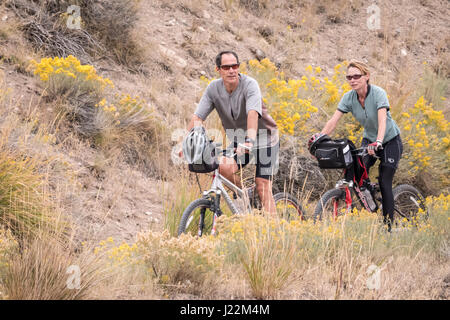 Paar Trail Radfahren in der Nähe der Mammoth Hot Springs Hotel im Yellowstone-Nationalpark, Wyoming, USA Stockfoto