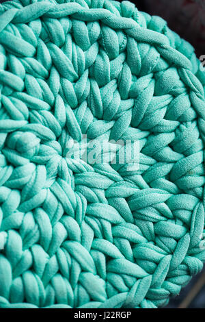 Textur. Türkis wird in einen Kreis von gestrickten Garn Stoff gehäkelt. In der Nähe Stockfoto