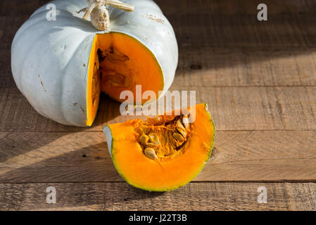 Ein Kronprinz Kürbis geschnitten und vorbereitet für das Kochen auf einem Holztisch. Stockfoto