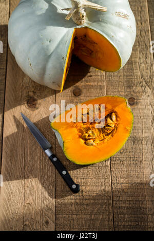 Ein Kronprinz Kürbis geschnitten und vorbereitet für das Kochen auf einem Holztisch. Stockfoto