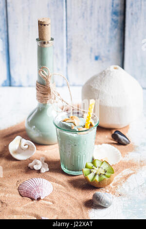 Blaue Smoothie mit Kokosmilch, Banane, Kiwi, Spirulina, beschichtet Kaffee Kokos-chips Stockfoto