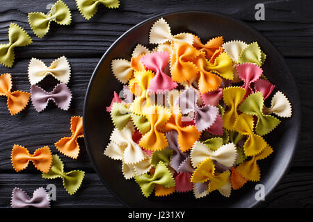 Italienischen rohen bunte Farfalle Nudeln close-up auf dem Tisch. horizontale Ansicht von oben Stockfoto