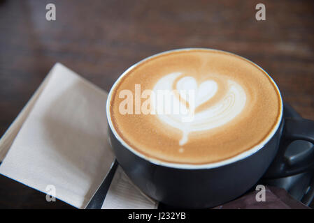 Latte Art Herz Form Kaffee Draufsicht auf Holztisch Hintergrund im Coffe-shop Stockfoto