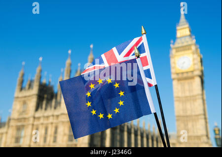 Flaggen der EU und UK Großbritannien fliegen gemeinsam solidarisch in strahlend blauen Himmel vor den Houses of Parliament, Westminster in London Stockfoto