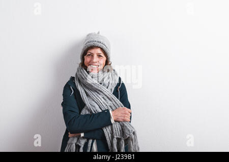 Ältere Frau in Schal und Mütze, Studio gedreht. Stockfoto