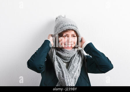 Ältere Frau in Schal und Mütze, Studio gedreht. Stockfoto