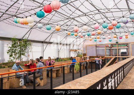 Menschen Essen und trinken in das Gewächshaus, ist eine große überdachte Folientunnel in Pop Brixton.Pop Brixton, Veranstaltungsort und die Heimat einer Gemeinschaft Stockfoto