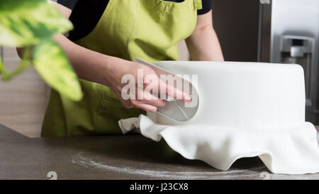 Nahaufnahme der Frau in Bäckerei dekorieren Kuchen mit Royal icing Stockfoto