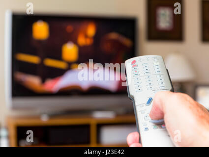 Die Person, die die TV und Kanal surfen können Sie über die TV-Fernbedienung Stockfoto