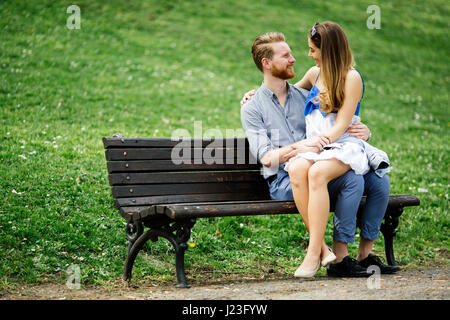 Romantisch zu zweit im Park sitzen auf Bank Stockfoto