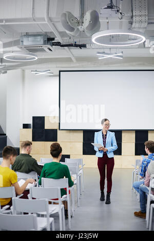 Junge Lehrer machen Rede vor Publikum im Hörsaal Stockfoto