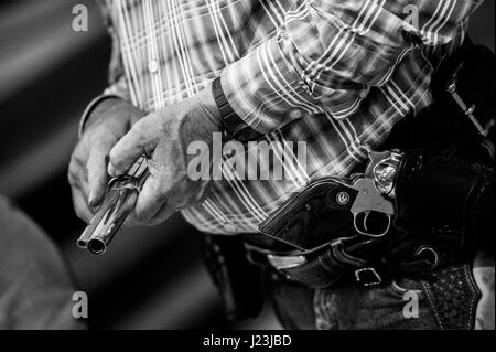 Salado, Texas, USA. Cowboy beritten schießenden Ereignis Texas. Mann-Fahrer wird die Waffe vor dem Wettkampf geladen. Stockfoto