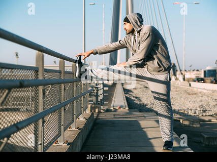 Schöne Sportler Mann tut stretching-Übung, Training vorbereiten. Fitness-Konzept Stockfoto