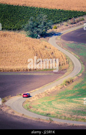 Kurvenreiche Straße und Autos Moravian Fields in Tschechien. Stockfoto