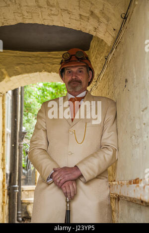 Ein Mann Dresssed im Steampunk Mode bei den Whitby Gothic Weekend-Feierlichkeiten in North Yorkshire, England, UK. Creme Farbe, orange Safari Hut Stockfoto