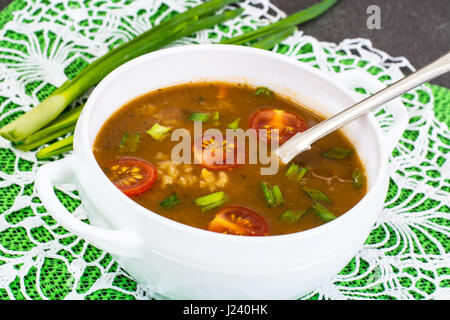 Würzige Suppe mit Curry, Reis und gegrillte Tomaten. Studio Photo Stockfoto