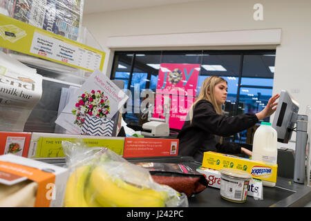 Eine junge Frau an der Kasse für einen Kunden an einem Seitenarm des Waitrose Supermarkt UK arbeiten Stockfoto