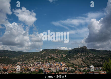 Stadtansicht von Bosa, Sardinien, Italien von oben. Bunte Häuser, Berge und Cumulus-Wolken an einem sonnigen Tag. Stockfoto