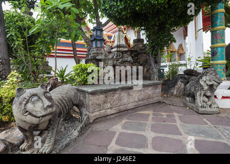 Statuen und Bäume in der Tempelanlage Wat Pho (Po) in Bangkok, Thailand. Stockfoto