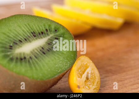 Nahaufnahme der Früchte auf ein Holzbrett. Kiwi und in Scheiben geschnittene Zitrone Stockfoto