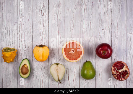 Zusammensetzung der Früchte in einem Schachbrettmuster auf ein weißes oder graues Holzbrett gelegt Stockfoto