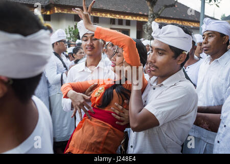 Kesiman, Denpasar, Bali, Indonesien. 23. April 2017. Balinesische Frau in Trance von hinduistischen Anhänger auf das Messer-Ritual der Sakral während der Pengerebongan Zeremonie selbst unterstützt. Eine Ritual, die dauert legen alle 210 Tage auf das balinesische Hindu Saka-Kalender. Kesiman Dorf in Denpasar ist einzigartig auf der indonesischen Insel Bali für diese besonders ungewöhnliche religiöse Zeremonie wo Hindu Anhänger ihren Glauben an Gott überprüfen, indem Sie versuchen das Undenkbare in Pura Petilan Tempel, Denpasar, Indonesien. Bildnachweis: Antony Ratcliffe/Alamy Live-Nachrichten. Stockfoto