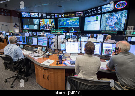 NASA Flight Director Brian Smith, links, Capcom Astronaut Jessica Meir, Zentrum und Astronaut Jeff Williams-Monitor-Aktivität in Mission Control als Präsident Donald Trump mit NASA-Astronauten Peggy Whitson und Jack Fischer an Bord der internationalen Raumstation ISS über Satellit aus dem Oval Office video 24. April 2017 in Houston, Texas spricht. Für den Rekord für kumulative Zeit im Raum, ein US-Astronaut gratuliert Trump Whitson. Stockfoto