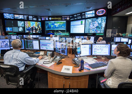 NASA Flight Director Brian Smith, links, und Capcom Astronaut Jessica Meir, Recht, überwacht die Aktivitäten in Mission Control als Präsident Donald Trump Gespräche mit NASA-Astronauten Peggy Whitson und Jack Fischer an Bord der internationalen Raumstation ISS über Satellit aus dem Oval Office video 24. April 2017 in Houston, Texas. Für den Rekord für kumulative Zeit im Raum, ein US-Astronaut gratuliert Trump Whitson. Stockfoto