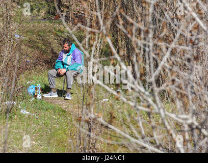 Mailand, Italien - 12. Juli 2016: Obdachloser auf Bank im Bronx Park nach dem Kampf für das Leben. Stockfoto