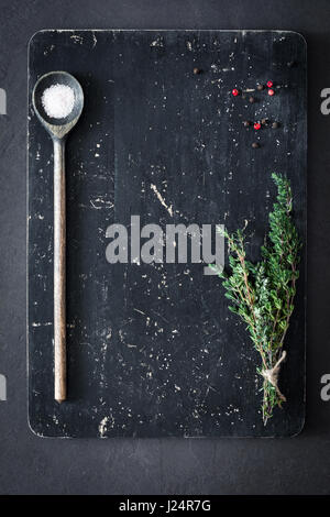 Thymian, Salz und Pfeffer auf Holzbrett, Ansicht von oben. Kochen Essen Hintergrund. Alten texturiert Cutting Board Hintergrund Stockfoto