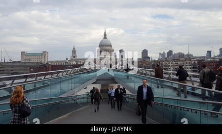 Pendler, die über die Millennium Bridge mit St. Paul's Kathedrale im Hintergrund zu arbeiten Stockfoto