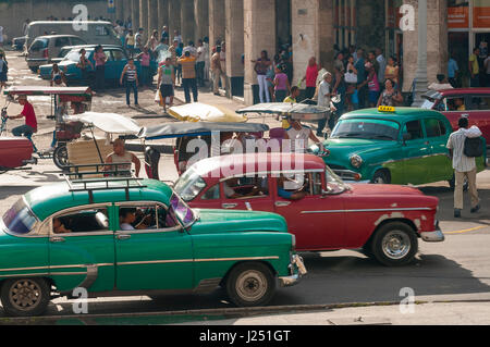 Havanna - Juni 2011: Autos, Fahrradrikschas und Fußgänger teilen sich die Straßen in einer typischen täglichen Szene vom Centro. Stockfoto