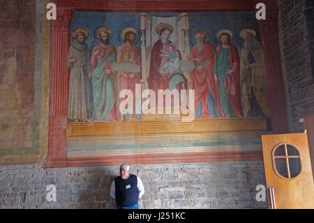 Ein Steward überwacht die Touristen, die sich in der Kirche von San Miniato al Monte in Florenz Stockfoto