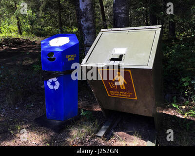 Tragen Sie Behältnis neben Recycling Container. Stockfoto