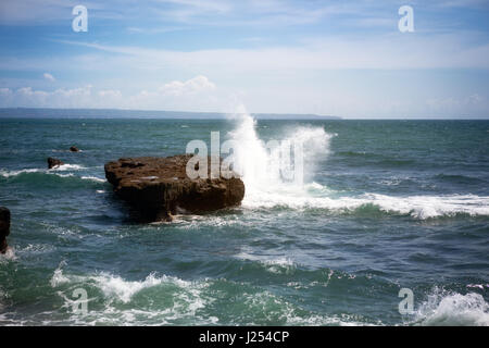 Surfen Sie an der Küste über die Felsen brechen Stockfoto