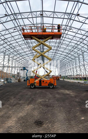Heben Sie mit Plattform-Arbeit im Lager Hangar Baubereich. Stockfoto