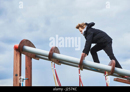 Kleiner Junge Klettern am Spielplatz Stockfoto