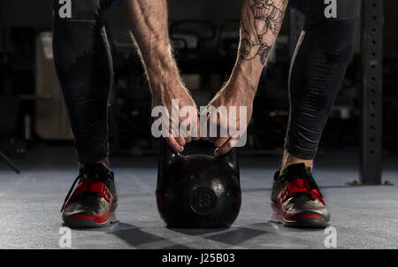 Nahaufnahme der muskulösen Mann tut ein Krafttraining durch Anheben einer schweren Kettlebell. Funktionelles Training. Stockfoto