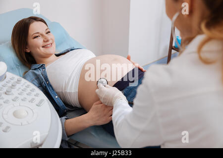 Positive Frau bekommen schwangeren Bauch Untersuchung im Krankenhaus Stockfoto