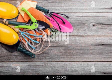 Gummistiefel und Gartengeräte. Stilleben auf Holzbrettern. Stockfoto